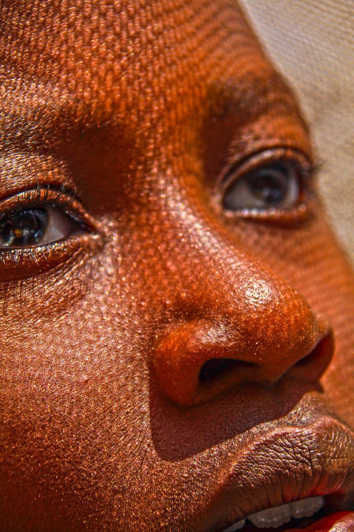 Close-up of a woman's eye, nose and cheek showing visible pores and skin texture