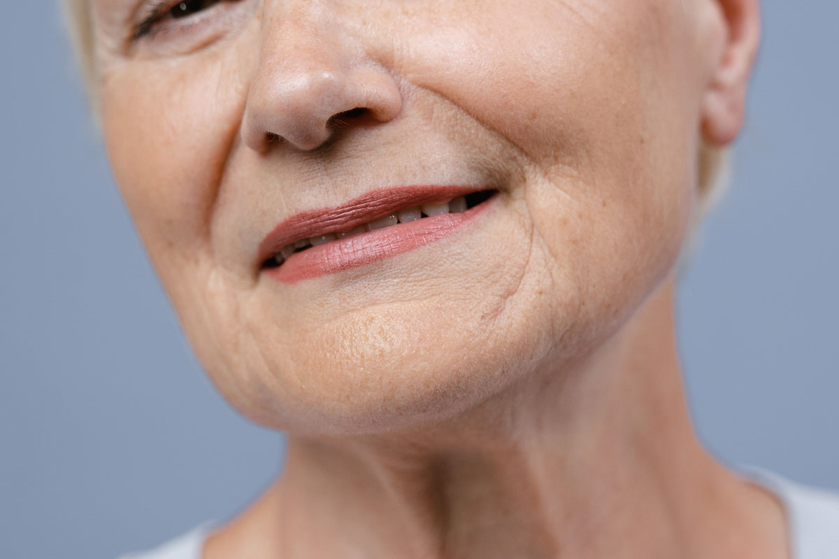 Close-up of a mature woman's smile showing fine lip lines and natural lip colour