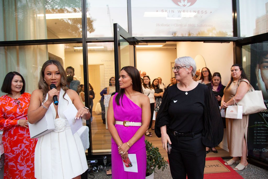 A full room of guests at the Skin Wellness Academy entrance as a speaker addresses the crowd